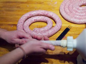 Wurst im Entstehen Spiralförmig abgelegte Wurst, noch am Wurstfüller befestigt