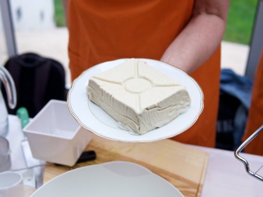 Selbst gemachter Tofu noch im Etamin Noch in Etamin eingehüllter, fertig gepreßter Tofu