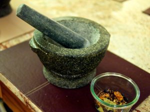 Mörser Die Gewürzmischung wird um Steinmörser zerkleinert