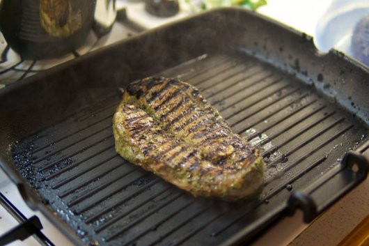 Ein Steak vom Lammschlögel brät in der Gußeisenpfanne
