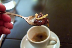 Eine halbe Tasse Hirschleber Hirschleber im Sud mit gerösteten Zwiebeln auf einem Löffel