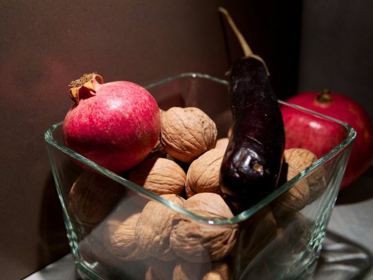 Granatapfel, Melanzani und Walnüsse in einer Glasschüssel