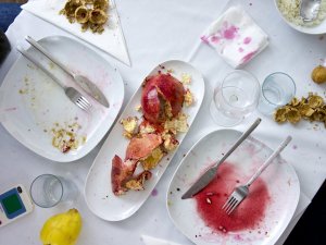 Was vom Festmahl übrig blieb Leere Teller, leere Gläser, Granatapfel- und Nußschalen, Servietten mit Granatapfelflecken