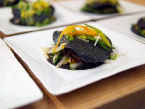 Offener Raviolo mit geschmortem Oktopus Die offenen Ravioli mit geschmortem Oktopus auf weißen Tellern angerichtet