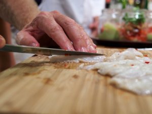 Ceviche kleinschneiden Die fertig "gegarten" Wolfsbarschfilets werden in mundgerechte Stücke geschnitten