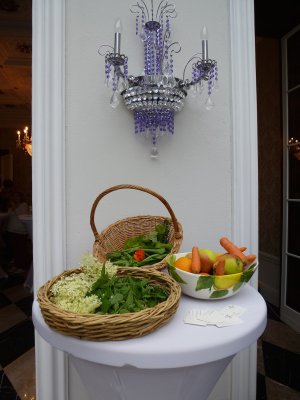 Zwei Körbe mit Kräutern und eine Schüssel mit Obst und Gemüse unter einer violetten Lampe