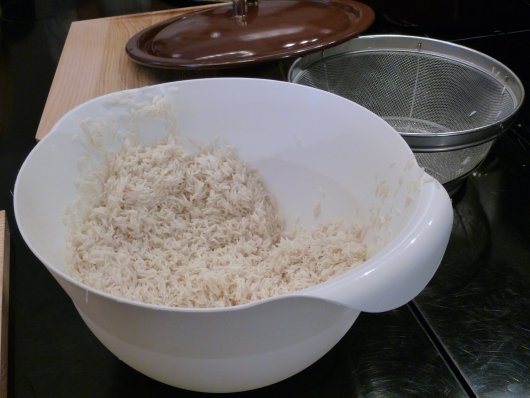 Eine Plastikschüssel mit gewaschenem Reis