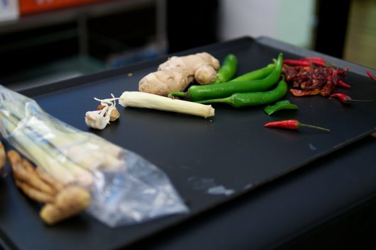 Die Zutaten für eine Thai-Curry-Paste: rote und grüne Chili, Ingwer, Galgant, Zitronengras, Knoblauch