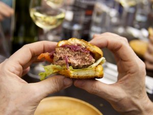 Briocheburger mit Rindfleisch-Grille-Heimchen-Laberl und Mehlwurm-Knusper Ein angebissener Briocheburger mit Rindfleisch-Grille-Heimchen-Laberl und Mehlwurm-Knusper