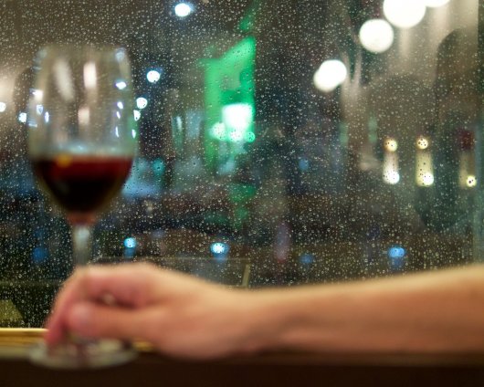 Ein Glas Picon Amer, im Hintergrund Regentropfen am Fenster der Brasserie Santner