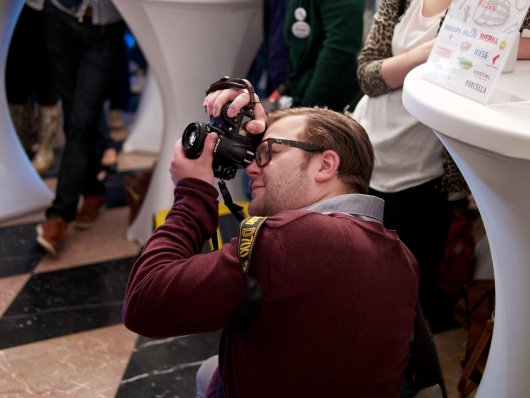 Bene Steinle kniet beim Photographieren am Foodcamp 2014