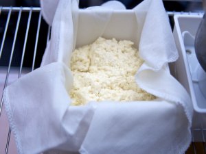 Fast schon Tofu Geronnene Sojamilch in einer mit Etamin ausgeschlagenen Tofupresse