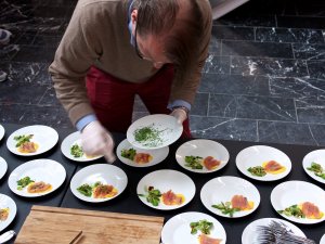 Johannes Ambros richtet an Johannes Ambros richtet Teller mit geräuchtertem Saibling an