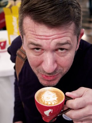 Roman Sindelar trinkt eine Tasse Meinl-Kaffee mit Latte-Art