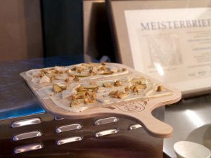 Flammkuchen mit Birne, Brie und Nüssen vor dem Backen Flammkuchen mit Birne, Brie und Nüssen vor dem Backen