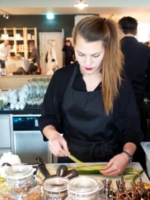 Vorbereitungen an der Bar Eine Barkeeperin bereitet Gurkenstreifen vor
